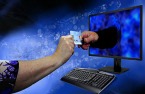Female hand giving credit card to hand inside computer screen.